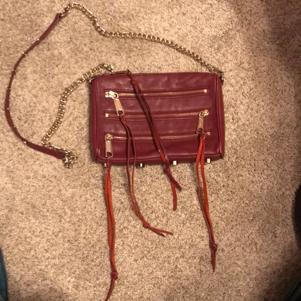 Burgundy 5 zipper cross body purse.